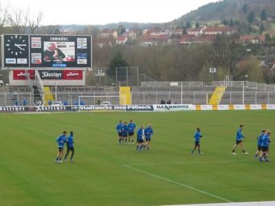 Die Paderborner Mannschaft muss beim Auslaufen ihren Trainer via Videowand ertragen
